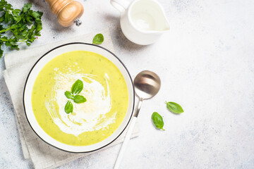 Zucchini soup with spinach and herbs at white.
