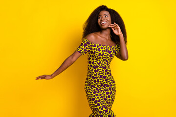 Portrait of attractive cheerful girl having fun walking touching face isolated over bright yellow...