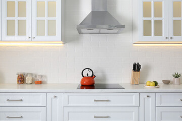 Fototapeta na wymiar Elegant kitchen interior with modern stove and stylish furniture