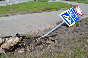 Damaged Broken Traffic Signs With Bus Direction Arrow and Pedestrian Crossing Road are Laying on the ground on a Street.