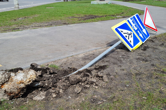 Damaged Broken Traffic Signs With Bus Direction Arrow And Pedestrian Crossing Road Are Laying On The Ground On A Street.