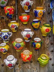 colorful ceramic souvenirs hanging on wooden wall in spain