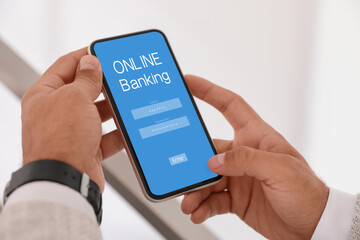 Man using online banking application on smartphone indoors, closeup