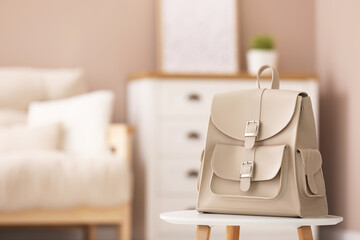 Stylish beige backpack on white table indoors, space for text