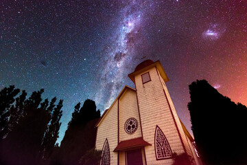 Little chapel in shores at Llanquihue lake against a starry sky with the milky way in Chile