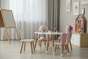 Child's room interior with stylish table, chairs and toys