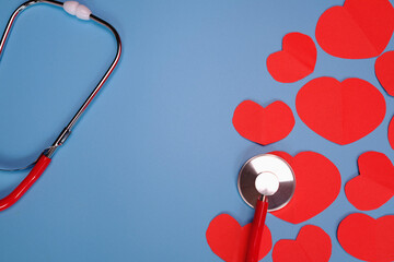 Red paper cut heart shape pasted on blue background