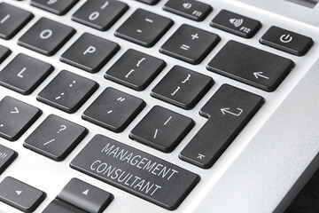 Button with text MANAGEMENT CONSULTANT on keyboard, closeup