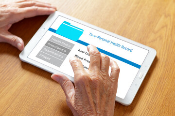 Mobile health concept: personal patient record on a tablet computer, hands of an old woman touching...