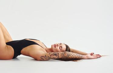 Fototapeta premium Beautiful seductive sporty woman with sexy body is posing in the studio
