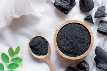 The black charcoal powder in the wooden cup was placed on a white cloth.