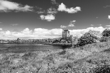 Dunguaire Castle on the shore of a lake in Galway Bay, Kinvara, Ireland in black and white