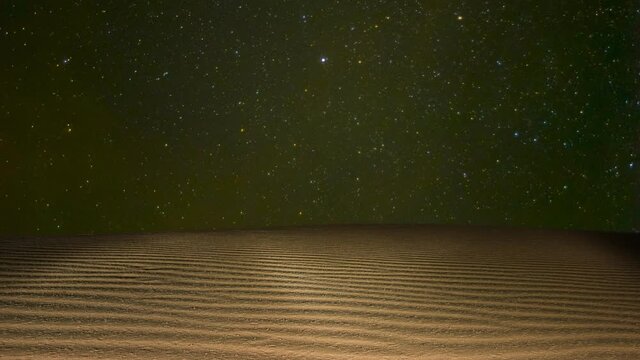 sandy desrt under rotate starry sky, night  time lapse scene