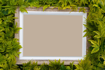 A real wooden frame covered with plants and leaves