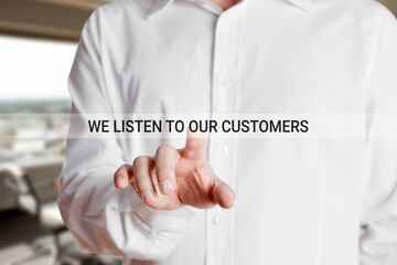 Businessman hand presses we listen to our customers a virtual touch screen. Customer care and...