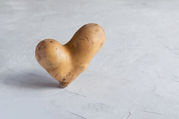 Ugly potatoes in the shape of a heart on a light gray background.
