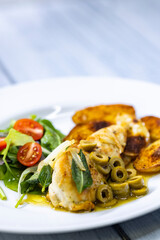 chicken breast baked on sage with green olive sauce with salad and potatoes