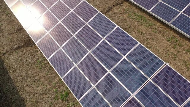 Aerial view of a solar farm producing clean renewable sun energy, industrial landscape from drone	