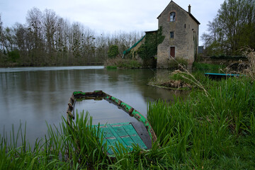 Moulin sur le Loir en pose longue avec présence d'une barque abandonnée 