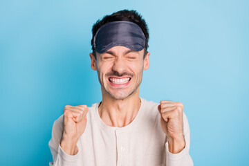 Portrait of cheerful lucky brunet guy wearing eye mask celebrating attainment having fun isolated over bright blue color background
