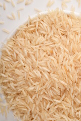 uncooked long brown rice isolated on white