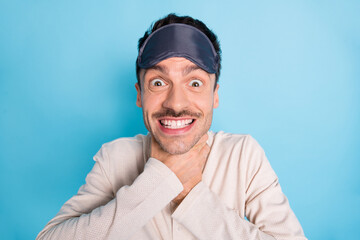 Portrait of nice cheerful funny brunet guy wearing sleep mask choking neck having fun isolated over bright blue color background