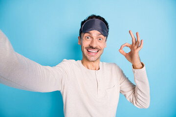 Naklejka premium Self-portrait of nice cheerful amazed guy wearing sleep mask showing ok-sign advert perfect isolated over bright blue color background