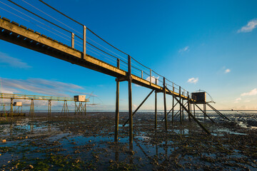 Obraz premium des carrelets ou pontons de peche à marée basse au soleil couchant
