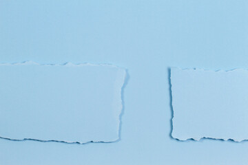 Abstract monochrome background. Pieces of torn paper on light blue background. Top view