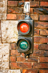 Vintage bicolor red and green traffic light on red brick wall