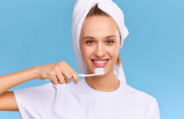 Cheerful young woman brushing teeth