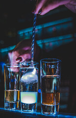 bartender making collection of colorful shots. Set of cocktails at the bar