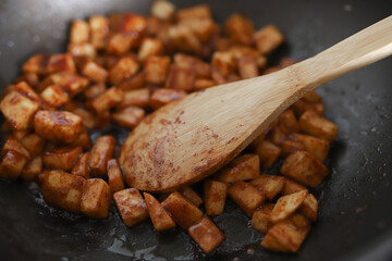Roast diced apples with cinnamon in a frying pan.
