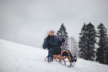 Teenager caught riding on a wooden sledge trying to adjust his direction with his hand and concentrating on his ride. In winter, the athlete goes down the piste on a historical object