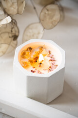 Home decoration with burning aromatic candle, white interior decor