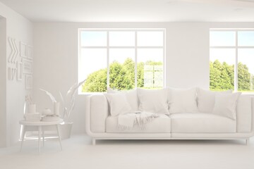Fototapeta premium White living room with sofa and summer landscape in window. Scandinavian interior design. 3D illustration
