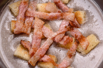 Fresh delicious hot puree soup with mushrooms and bacon in a black plate