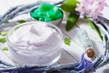 cosmetic cream product samples with hyacinth flowers on white wooden background