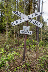 Old sign of railroad crossing on spring trees background