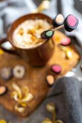 wooden coffee cup, dry yellow flowers, licorice candy,.  top view, layout,