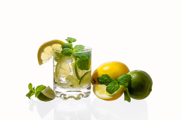 Citrus lemonade with ice in a glass decorated with lemon, lime and mint slices and on a white background. Fresh summer drink. Detox. Healthy food rich in vitamins and antioxidants. Copy space