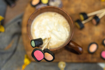 wooden coffee cup, dry yellow flowers, licorice candy,.  top view, layout,