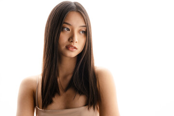 Naklejka premium Young asian brunette woman posing and looking aside