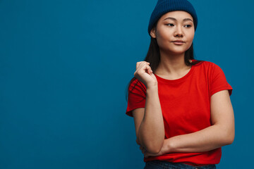 Asian teen girl in hat posing and looking aside