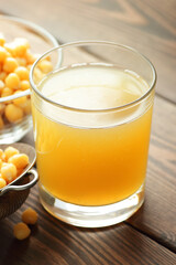 Boiled chickpea water - aquafaba with beans and blue napkin on wooden table nearby, closeup, vertical, egg substitute, protein vegan food concept