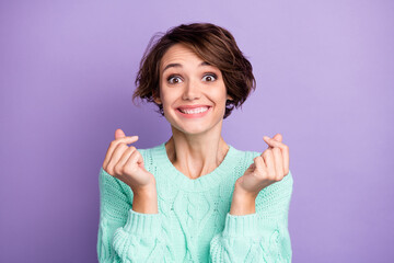 Portrait of attractive cheerful funny brown-haired girl showing love gesture isolated over violet purple color background