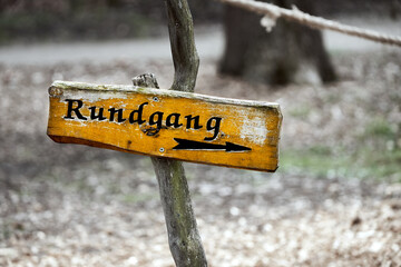 Yellow sign on a crooked branch with German inscription tour around.