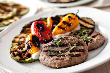 Hamburger with grilled mixed vegetables on a plate.