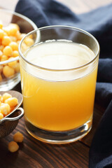 Boiled chickpea water - aquafaba with beans and blue napkin on wooden table nearby, closeup, vertical, egg substitute, protein vegan food concept
