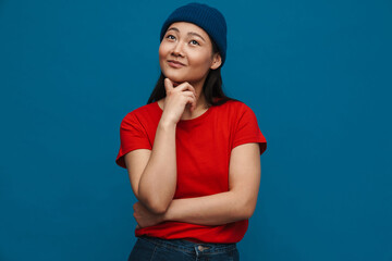Asian teen girl in hat smiling and looking upward